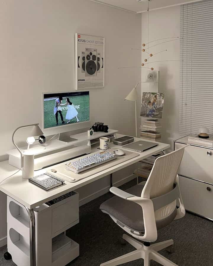 White-toned home office space featuring a white desk and chair, creating a neat and modern atmosphere
