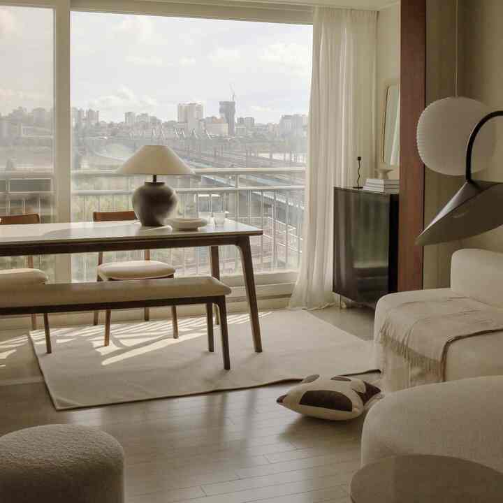 ベージュとブラウンの色調のリビングとダイニングルーム、食卓と椅子が自然な雰囲気を演出する空間