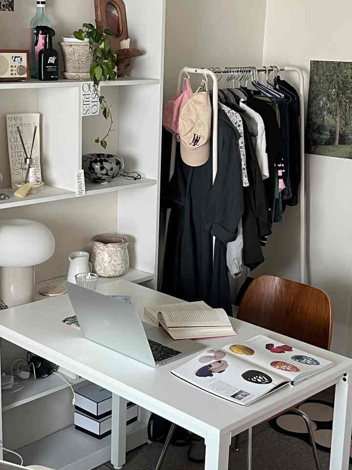 白と木目調が調和した一人暮らし用ホームオフィス、デスクと本、椅子が配置された雰囲気のある作業空間