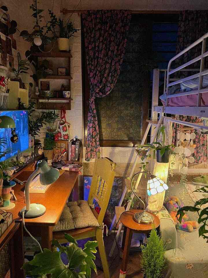 温かみのある木目調と緑の植物が配置された、居心地の良い6畳の寝室兼ホームオフィスの雰囲気あるインテリア