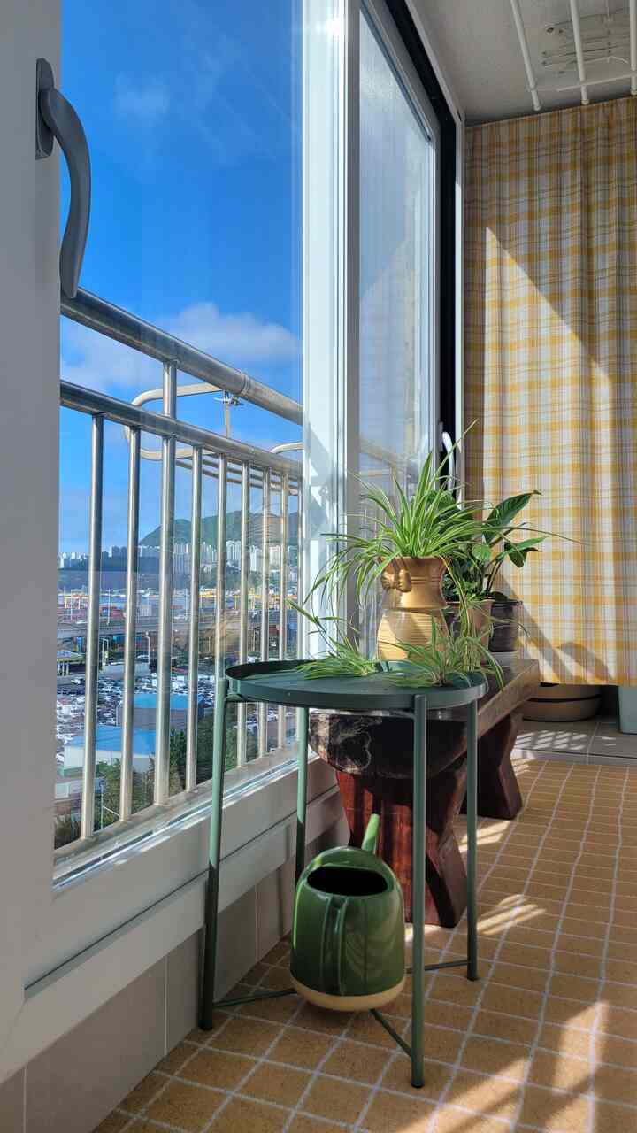 Yellow check curtain and wood furniture in a veranda space, featuring natural light and plants with a calm natural atmosphere