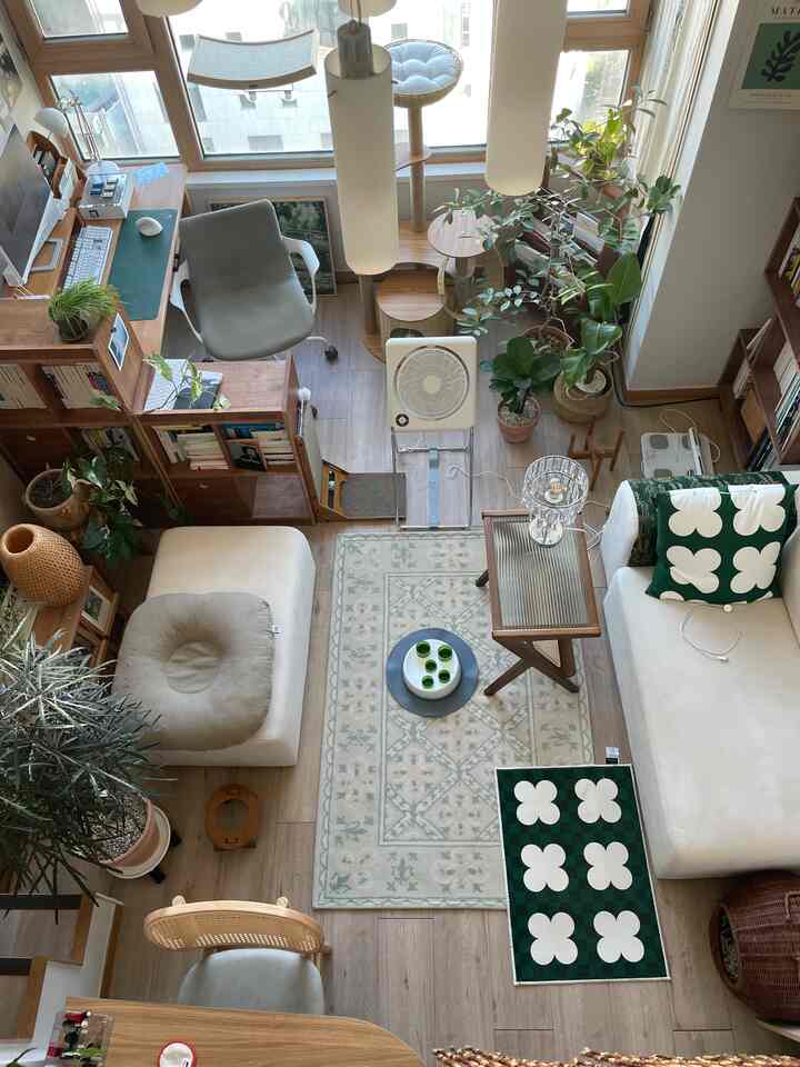 木目調と白が調和したロフトスタイルの複層オフィステル、机とソファ、多数の植物が配置されたモダンでナチュラルな空間