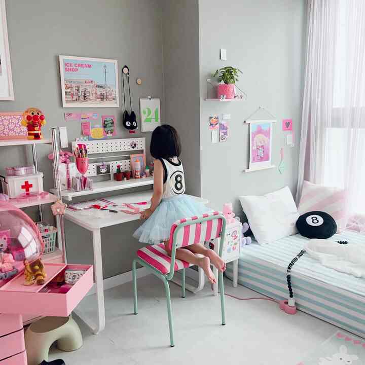 Natural gray toned kids' room featuring pink striped chair, study desk, and bed in a cozy children's space