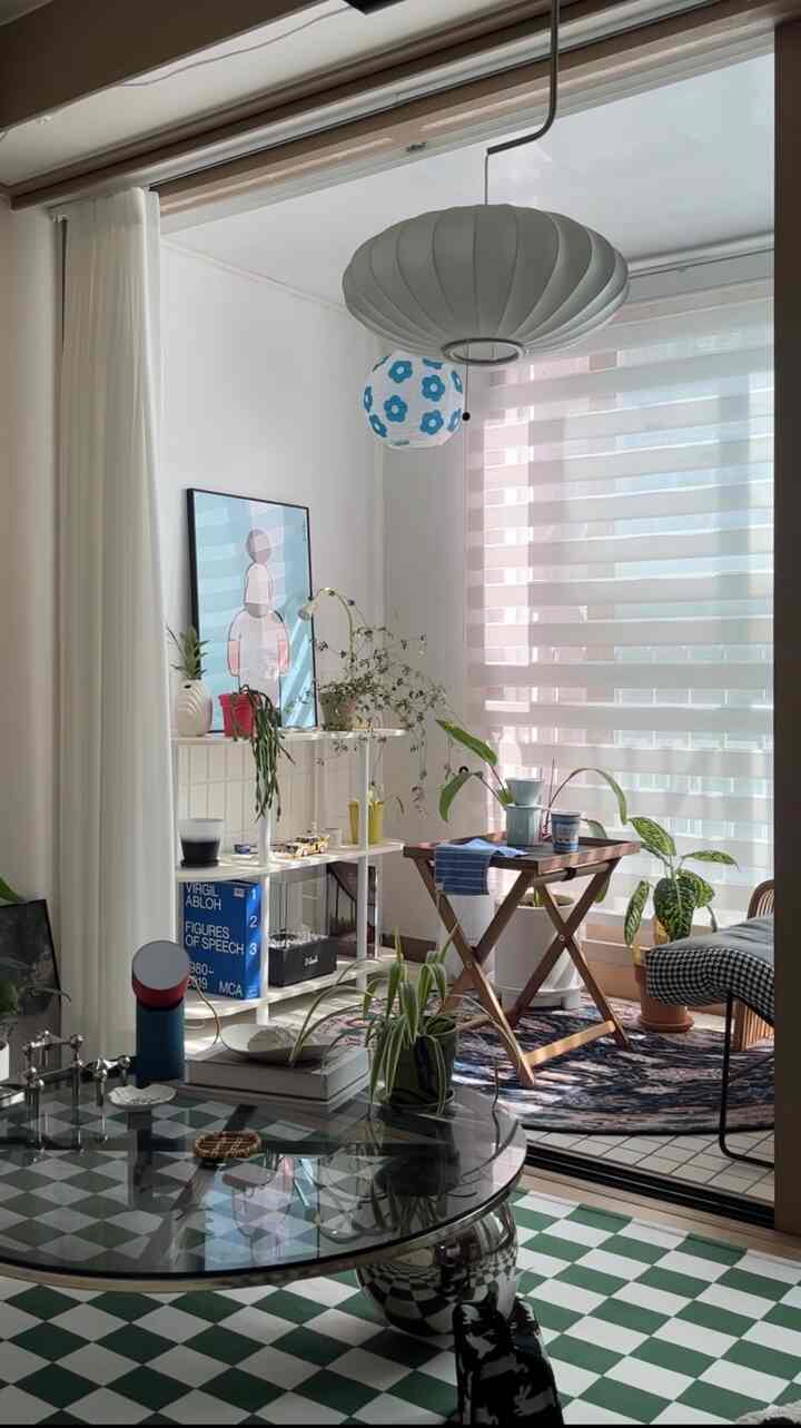 ホワイトとグリーンのトーンのベランダ、棚と植物が配置された自然で明るい雰囲気のあるインテリア