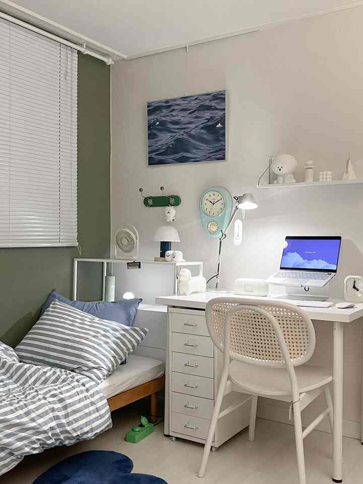 White and green toned small bedroom featuring a desk and bed with a simple, minimalist atmosphere