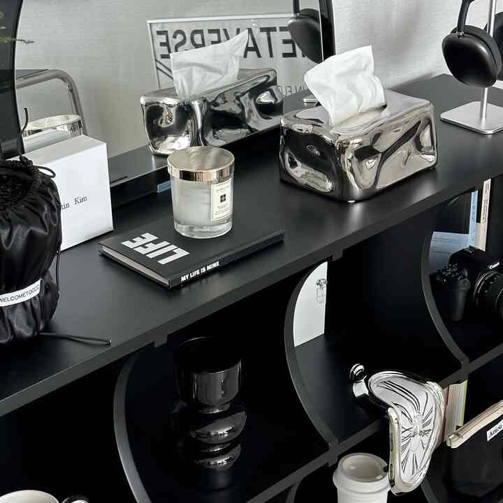 Monotone and black mid-century modern interior space featuring decorative accessories on a curved shelf