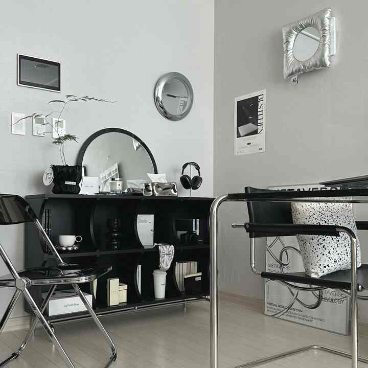 モノトーンとシルバーの色調が特徴的なミッドセンチュリーモダンの部屋、黒い金属製フレームのデスクとチェアが配置された洗練されたインテリア