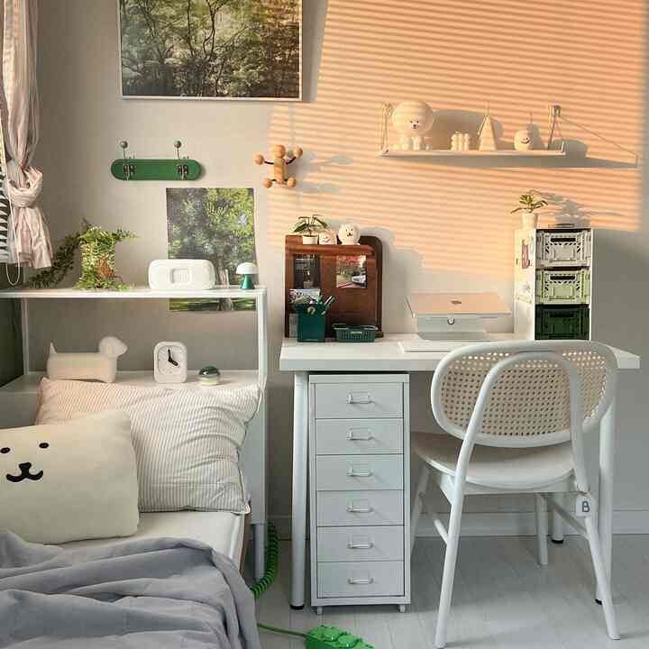 暖かな陽射しが差し込むホワイトトーンの寝室とデスクが配置された居心地の良いワンルーム