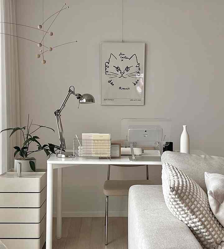 白とナチュラルカラーの調和がとれたリビング、シンプルなデスクとソファが配置されたモダンな雰囲気のインテリア