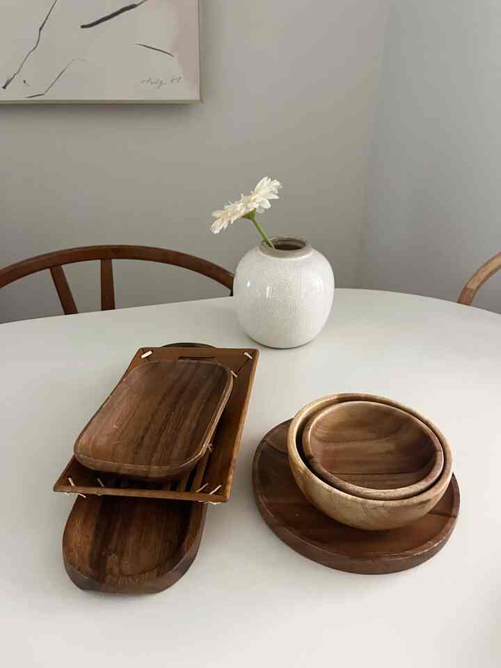 ナチュラルカラーでシンプルなダイニングテーブルに木製の器とトレイが配置された雰囲気のあるインテリア