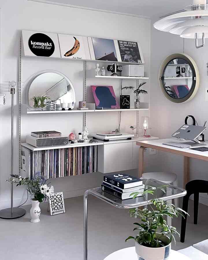 White and gray toned home office featuring wall shelves with LPs and posters in a clean Mid-Century Modern style space