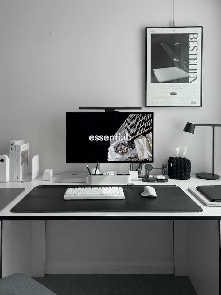 ホワイトとブラックのモノトーン配色のワンルームホームオフィス、モニターと机周りが整ったシンプルモダンな雰囲気のあるインテリア