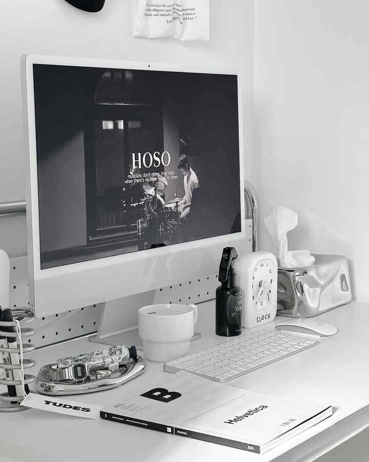 White and silver toned home office desk featuring Apple iMac, accessory tray, and tissue case in a clean mid-century modern style setup