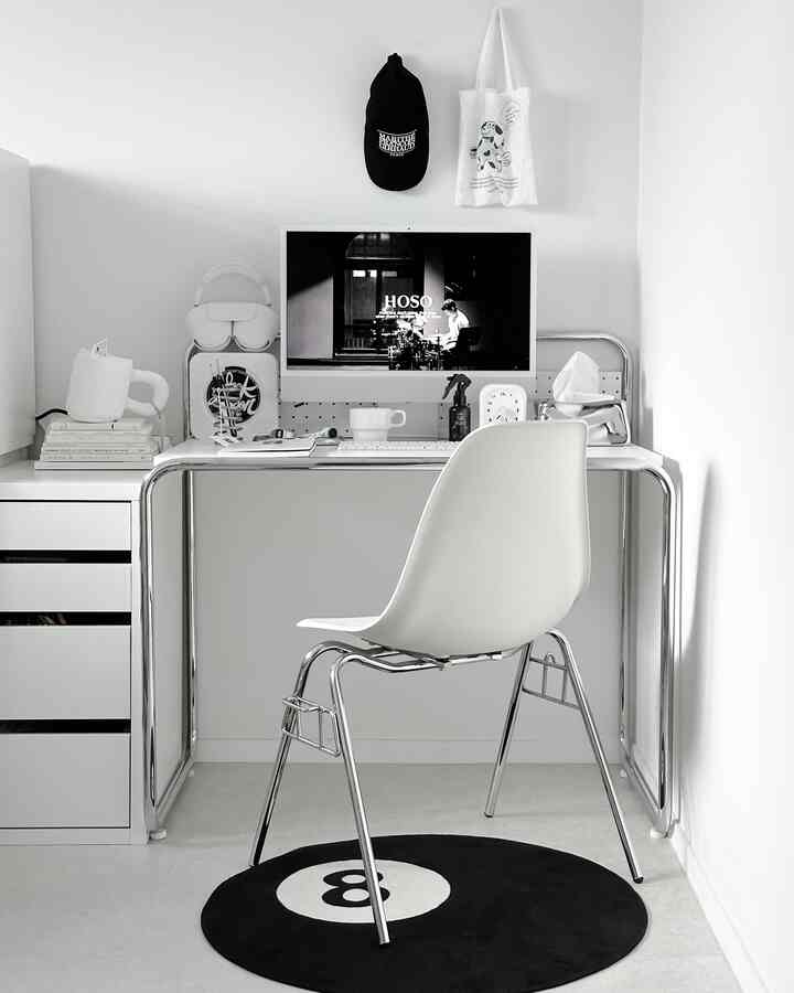 ホワイトとブラックのモノトーンでまとめられたミッドセンチュリーモダンのホームオフィス、整理された机と椅子が配置された小さな空間