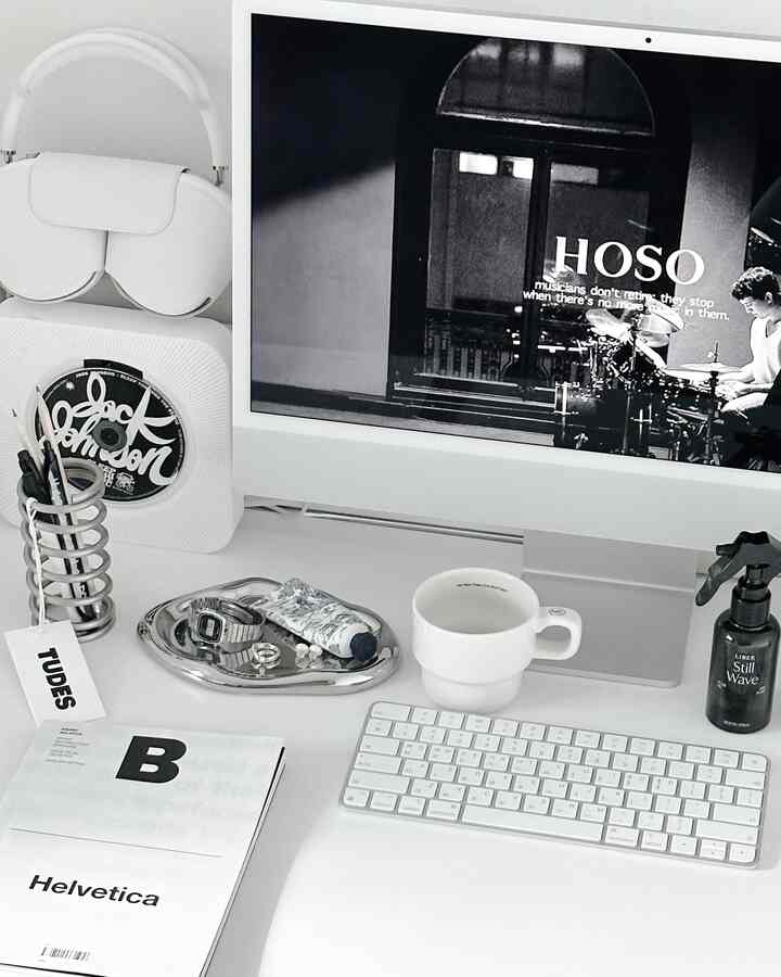 White and silver toned home office desk featuring Apple iMac and accessory tray arranged neatly in a mid-century modern style space