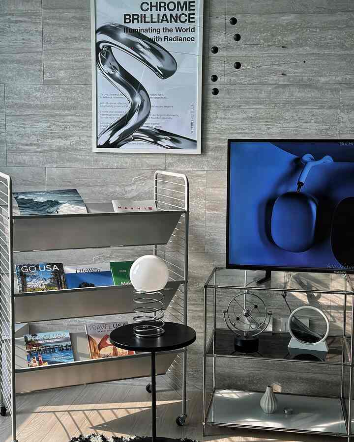 Silver and gray toned space featuring a chrome mobile and framed art on the wall, showcasing a modern and sleek interior