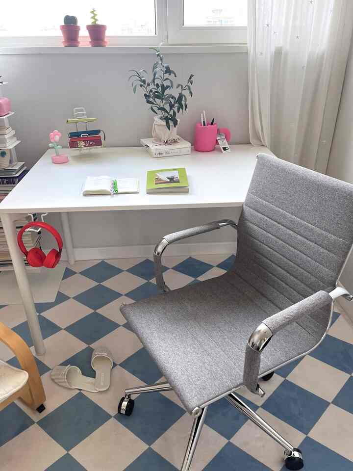 White and gray toned study featuring a mid-century modern office chair and desk in a cozy home office setting