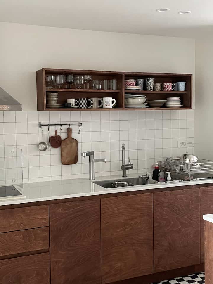 Clean kitchen interior featuring wood tone cabinetry and white tile backsplash in harmony