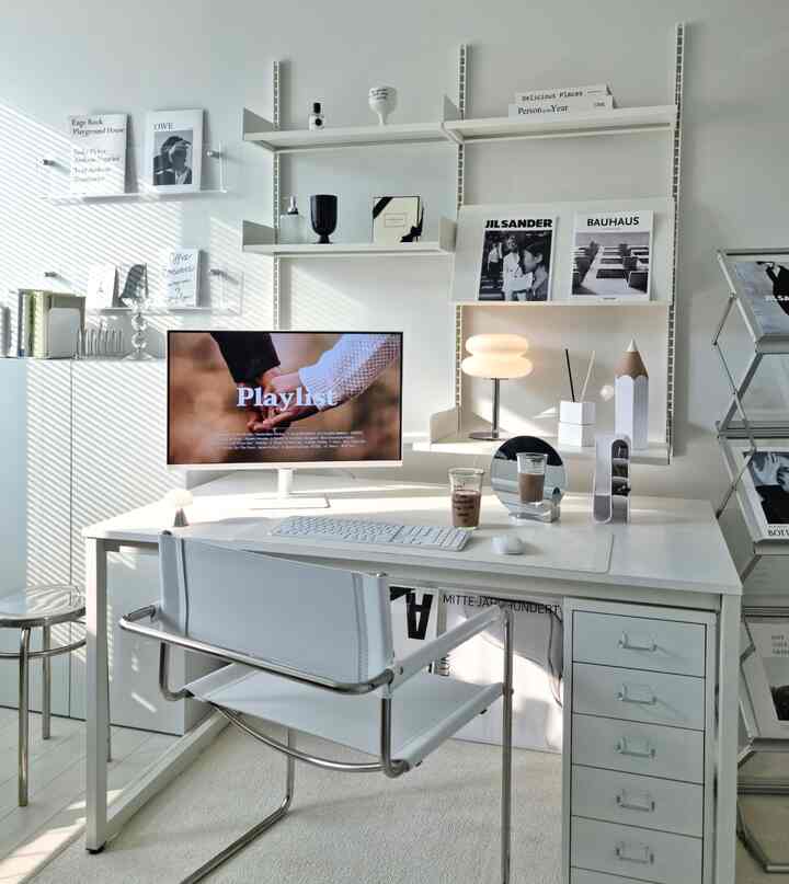 White-toned study featuring a neat desk, round globular lamp, and mid-century modern style elements