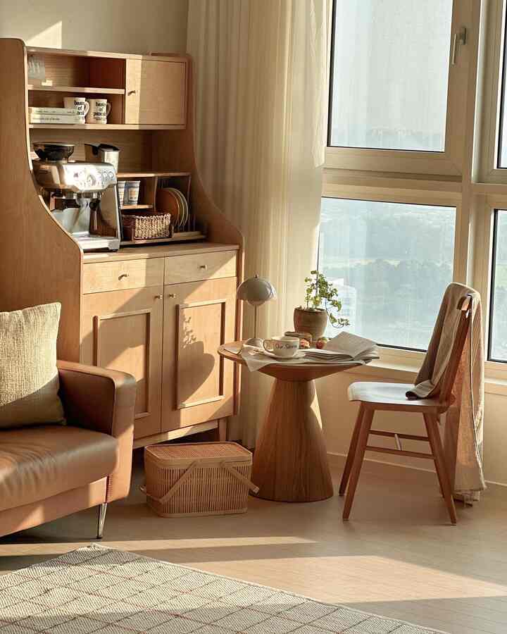 Warm wood-tone living room featuring a sofa, coffee machine for home cafe, side table, and cozy natural light atmosphere