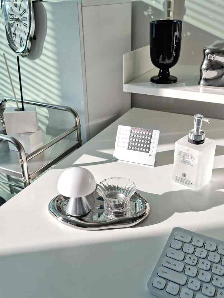 Modern desk interior with silver metal tray, LED mood lamp, and dispenser on white-tone desk surface