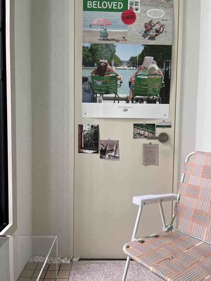 ナチュラルな色調のバルコニー、オレンジ色のアクセントチェアとポスターが配置された心地よい休憩スペース