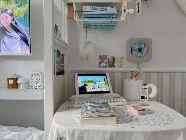 白とグレーのトーンの一人暮らし向けホームオフィス、机の上にタブレットと本、キーボードが配置された落ち着いた空間