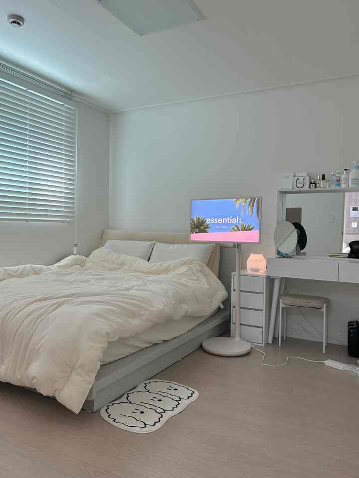 白とナチュラルカラーの寝室、大型ベッドと化粧台が配置された清潔感のある空間