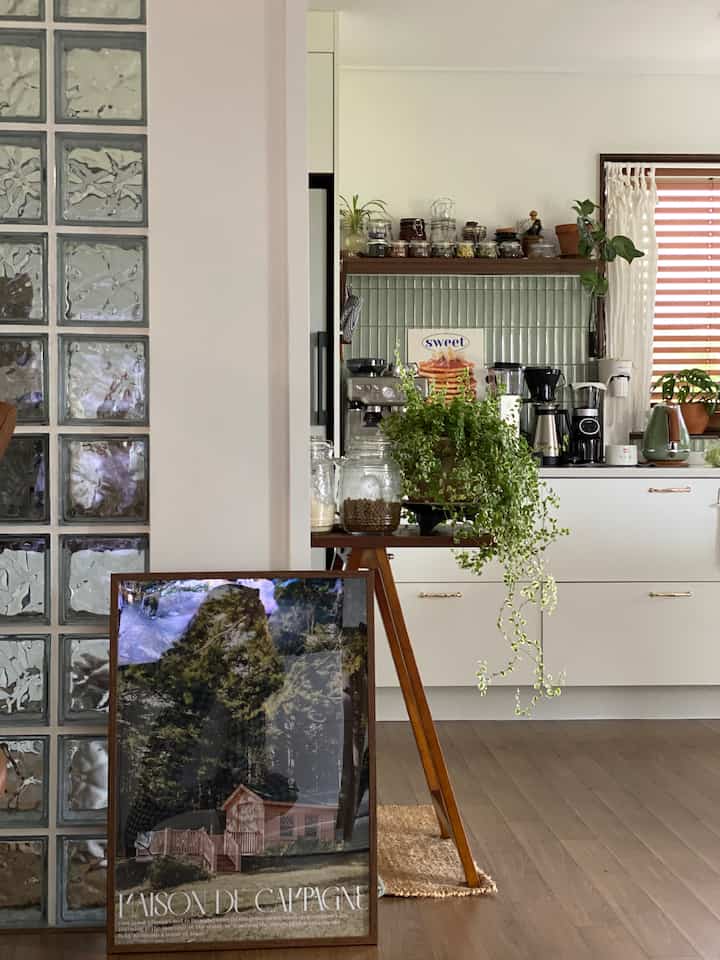 Natural wood tones and green plants featured in a cozy kitchen and living room corner space