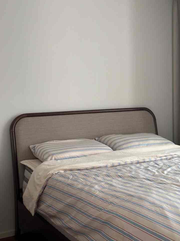 Warm retro mood bedroom featuring a natural brown bed with beige and blue striped duvet cover