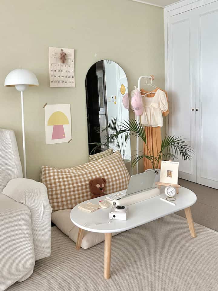 Natural tone living room featuring a white tabletop with wooden leg floor table and simple furniture in a minimalistic setting