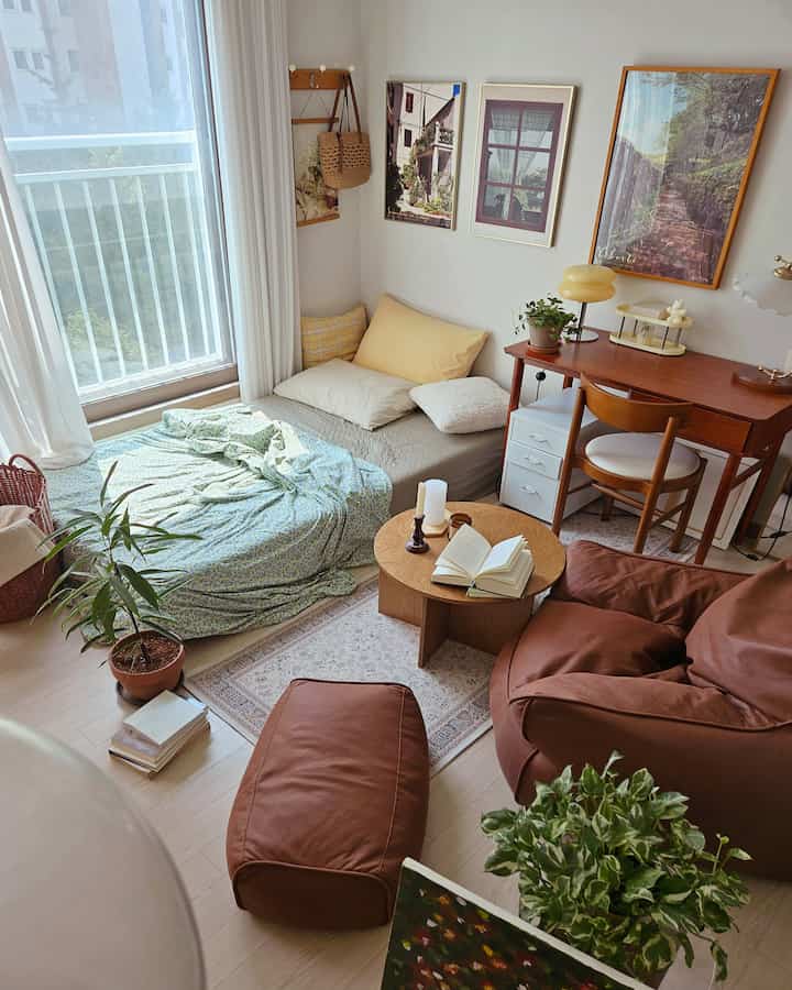 自然な色調が特徴の、日当たりの良い窓辺にベッドと作業スペースを備えた居心地の良いワンルーム