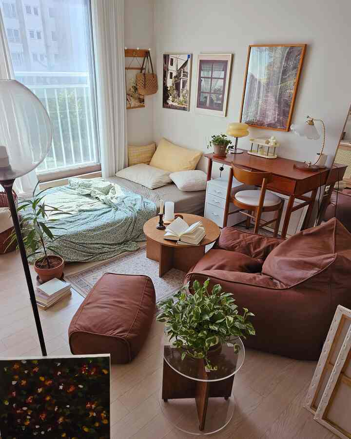Beige and brown toned studio bedroom featuring floor bedding and sofa bed in a cozy natural setting