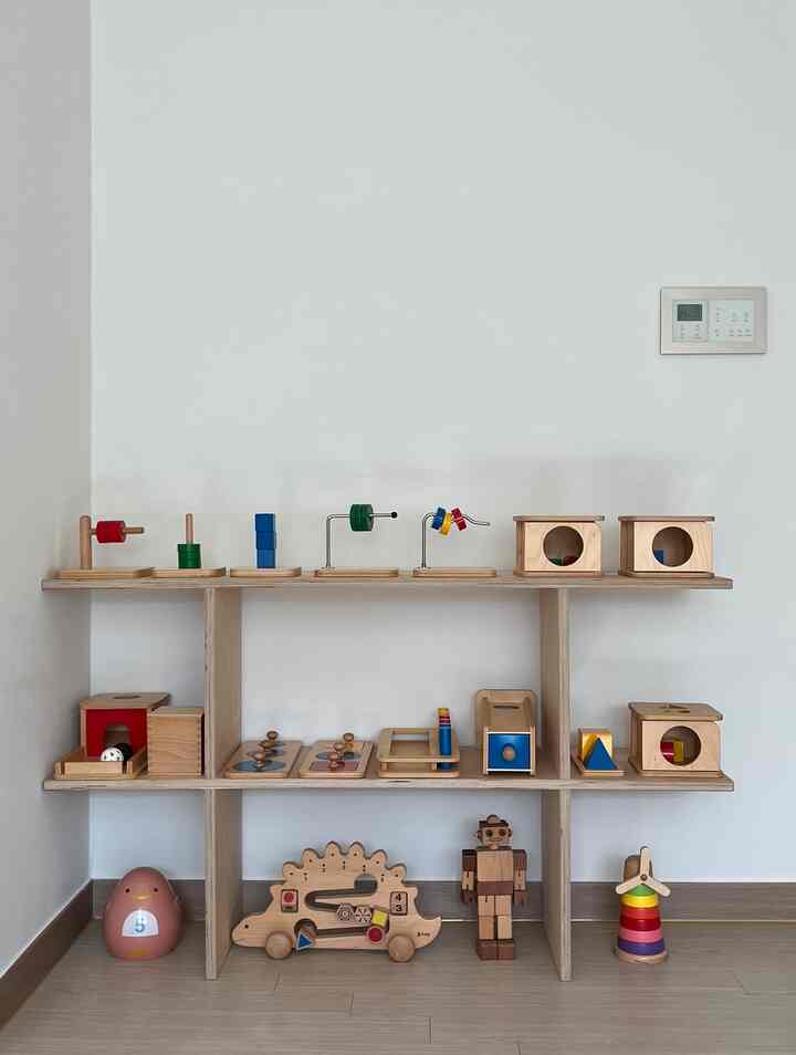 ナチュラルな木目調の子供部屋、モンテッソーリ教具とおもちゃが整理された棚が置かれた雰囲気のある空間