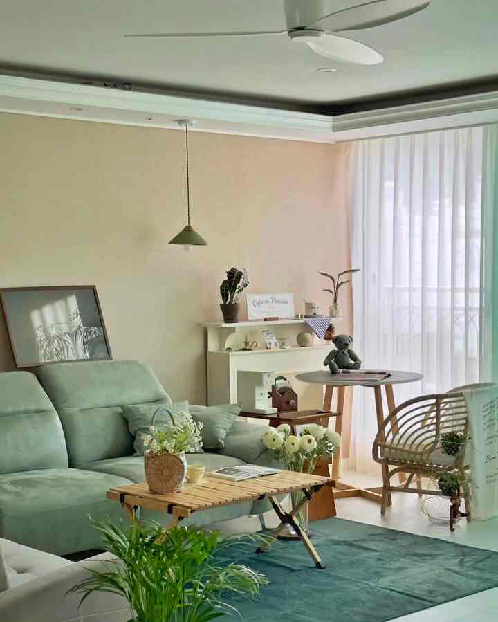 A living room with mint-colored sofa and wood tone furniture, featuring white and natural colors creating a cozy and warm atmosphere