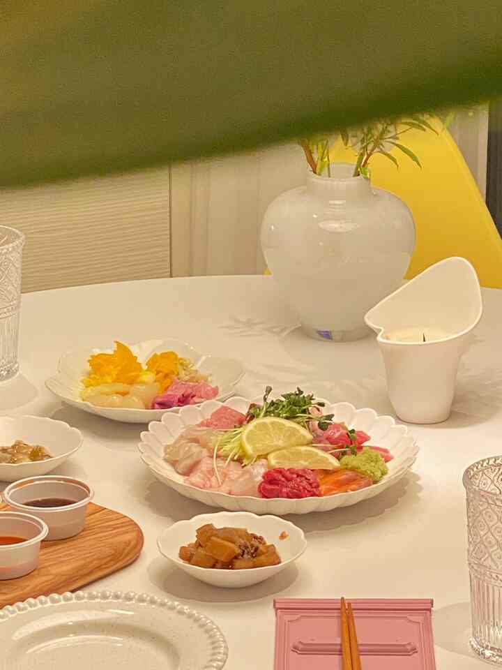 White and yellow toned dining room featuring plates with food and a vase, evoking home bar ambiance