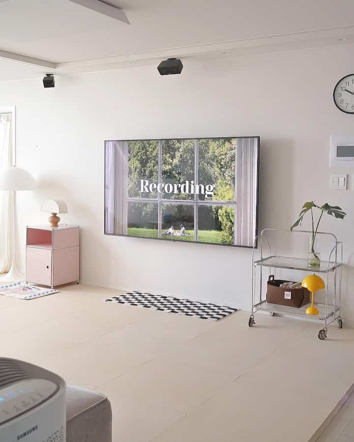 Bright white and natural color toned living room featuring a wall-mounted TV and modern furniture in a clean music zone