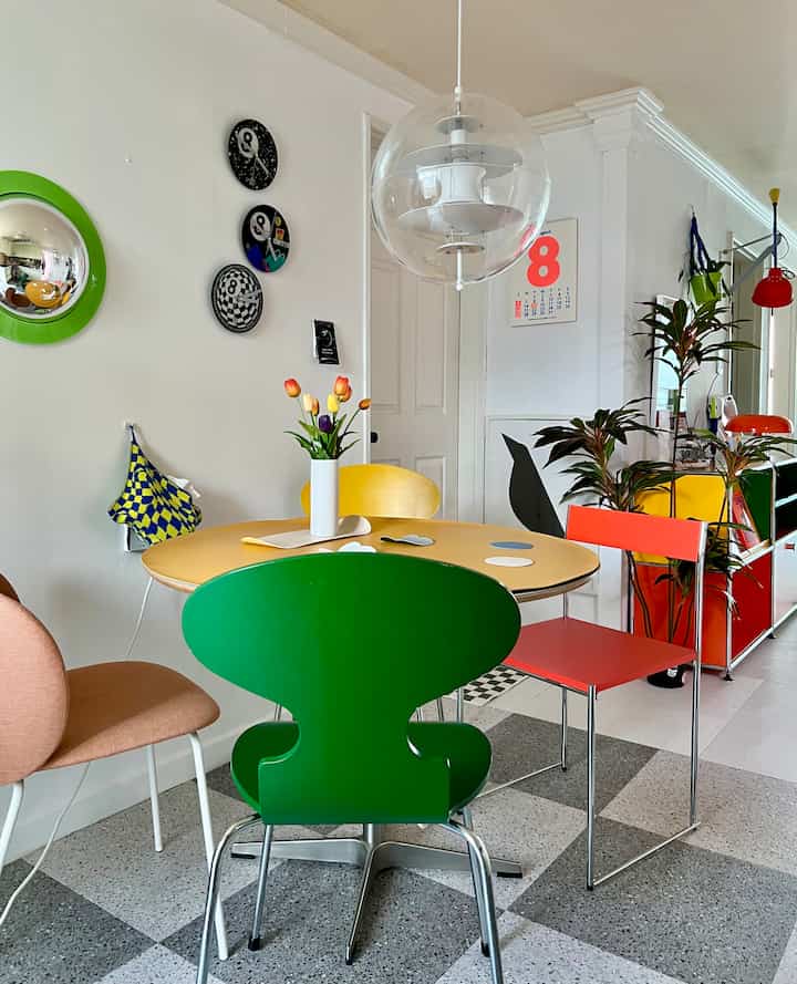 Bright yellow round dining table with multicolored chairs in a modern kitchen space