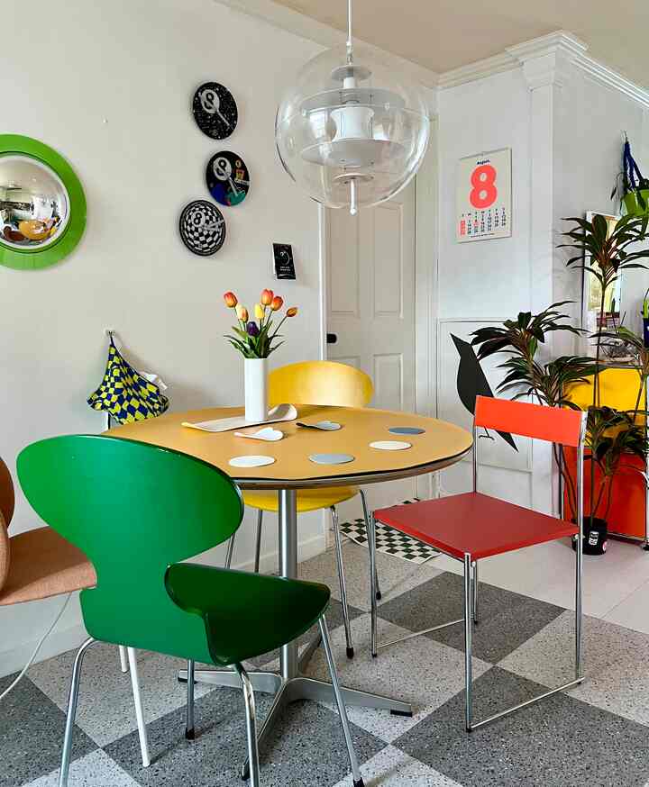 Bright and fresh dining room featuring a yellow table and colorful chairs with minimalist decor