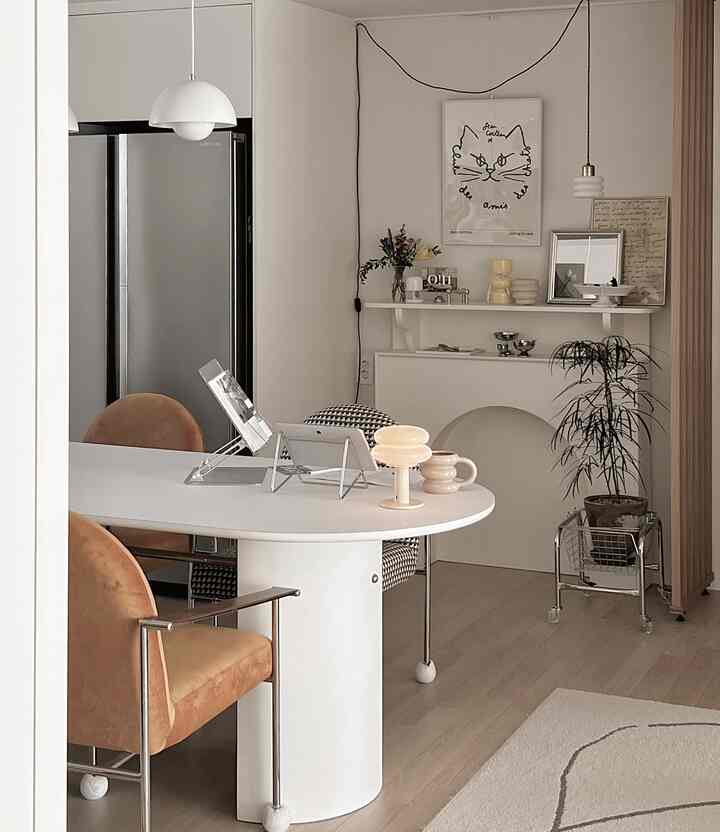 ホワイトトーンのダイニング、ミッドセンチュリーモダンのテーブルとチェアが配置された印象的な空間