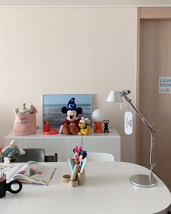 White and natural toned kids' room featuring desk accessories and children's toys arranged on a desk with a cozy atmosphere