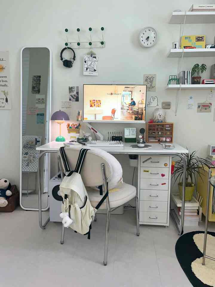 白を基調としたミッドセンチュリーモダンスタイルの整ったホームオフィス、机とモニターアームが配された印象的な空間