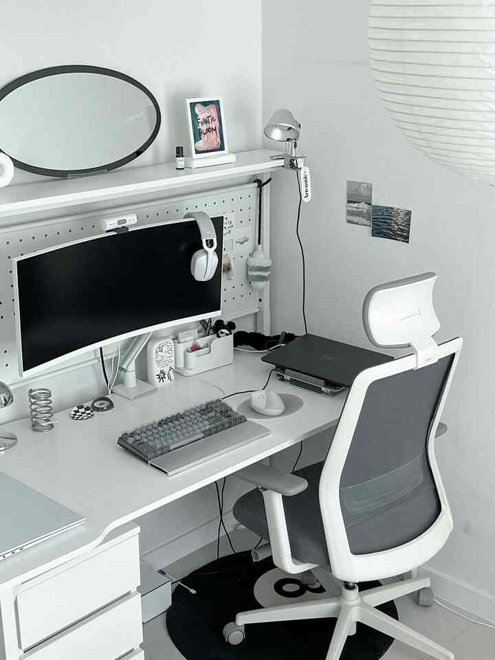 White and gray toned home office with monitor and desk lamp arranged in a neat workspace