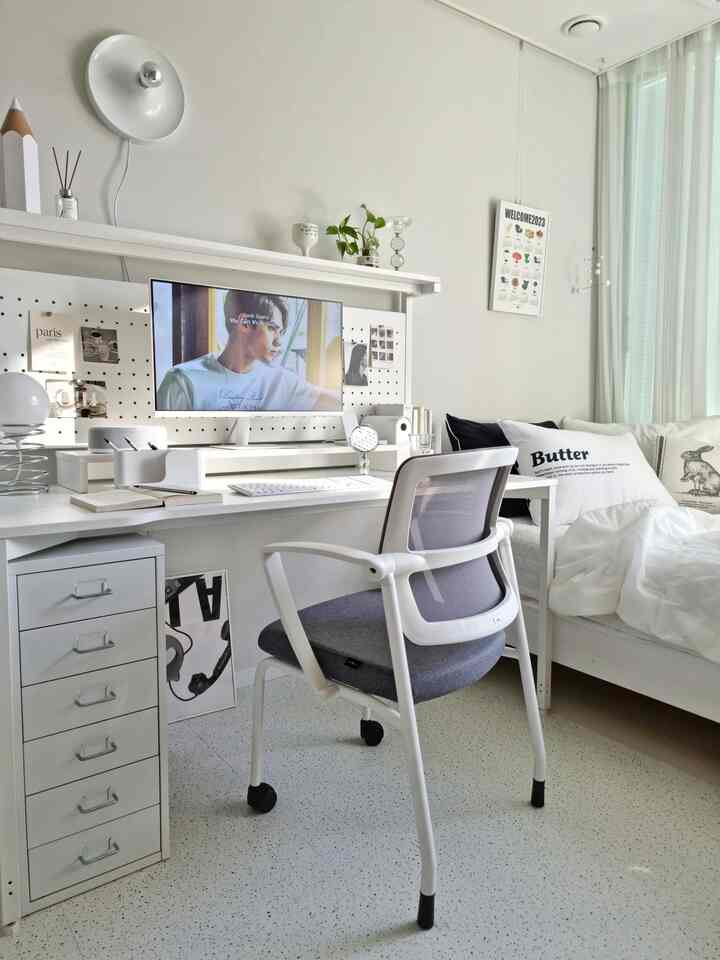 Bright white-toned kids' room featuring a computer desk, storage drawers, and a comfortable desk chair in a tidy study space