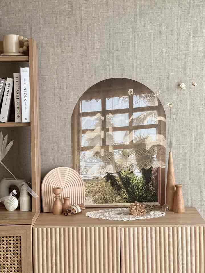 暖かいベージュトーンのリビングコーナー、木製家具と感性のあるオブジェが配置された自然で落ち着いた空間