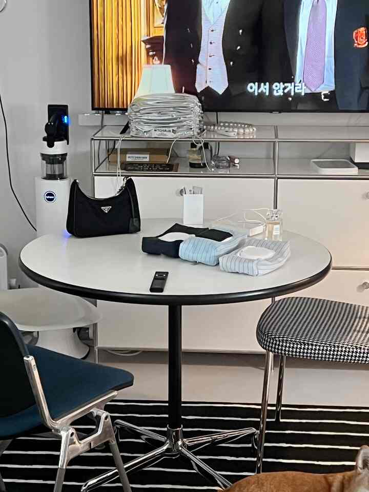 モダンな白と黒の色調のダイニングルーム、丸いテーブルと2脚の椅子が配置されたすっきりとした空間