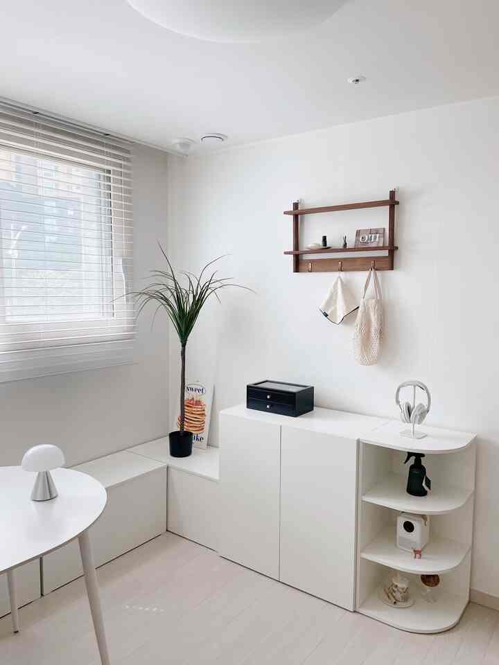 白とナチュラルな色調のシンプルな玄関空間、隙間収納とベンチ型収納が配置された清潔感のあるインテリア