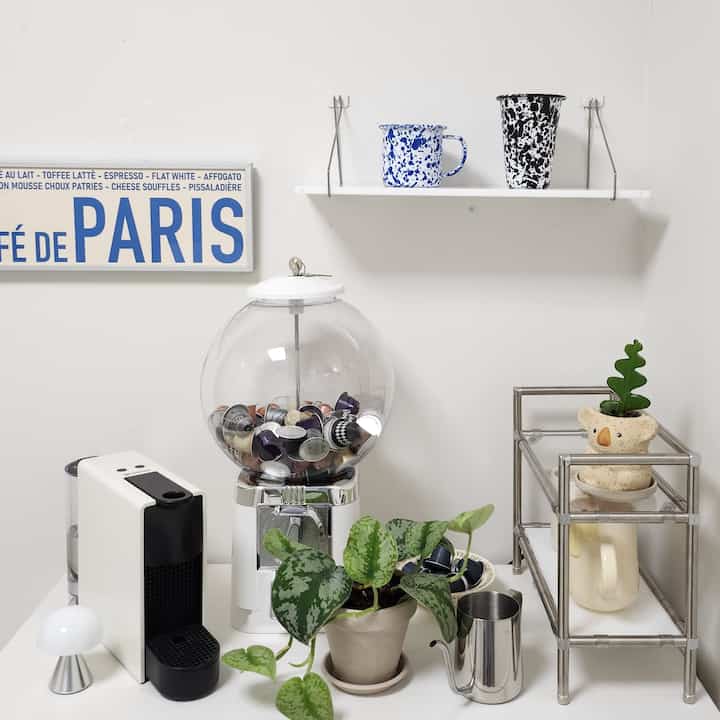 White-toned kitchen space featuring home cafe elements and plants with a neat and cozy atmosphere