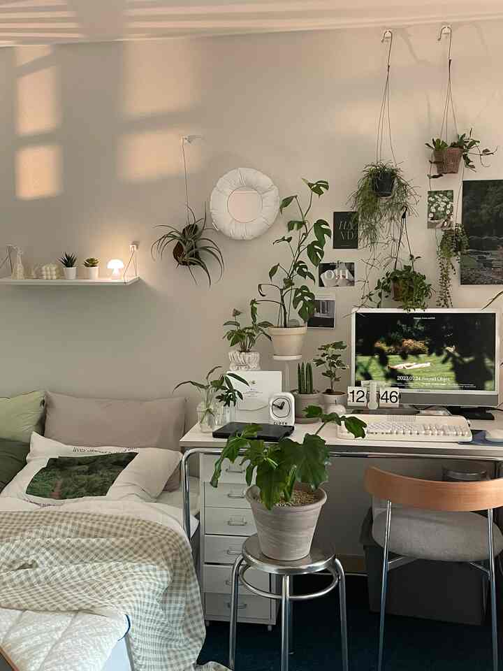 White and beige toned bedroom and home office space featuring abundant plants and natural decor creating a cozy atmosphere