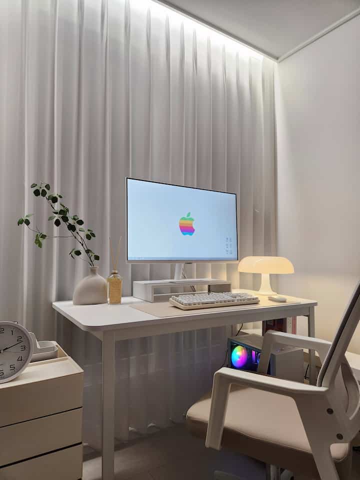 ホワイトとベージュのトーンが特徴の小さなホームオフィス、モダンなデスクとオフィスチェアが配置された清潔感あるコンピュータールーム